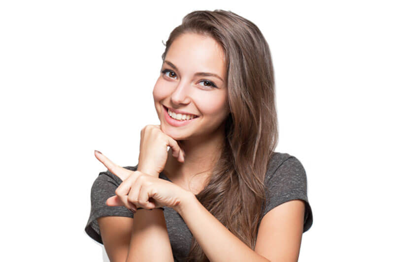 ).  Picture of a smiling woman with long brown hair, showing her happiness with her dental bridge she had done at Premier Holistic Dental in Costa Rica.