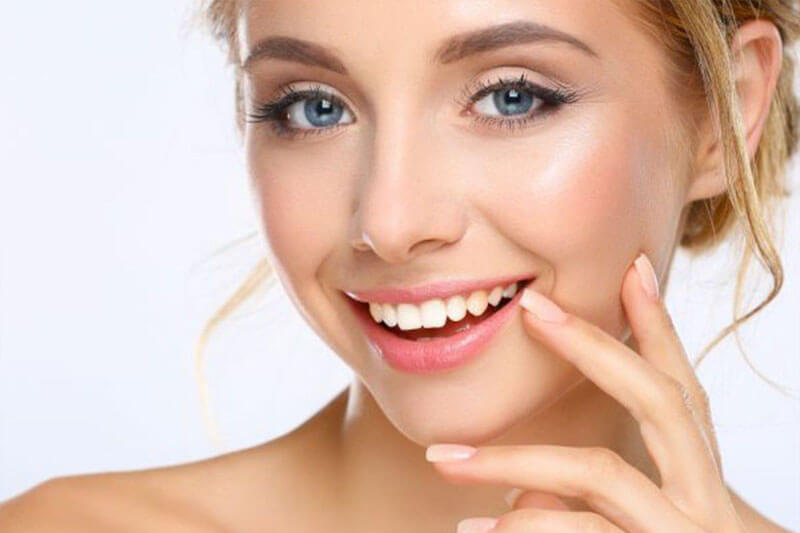 Close-up picture of a smiling woman, happy with her dental inlays/onlays she had at Premier Holistic Dental in Costa Rica.