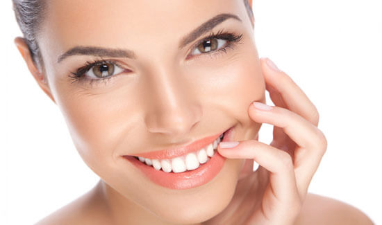 Close-up portrait picture of a smiling woman with short hair and with perfect teeth, looking directly at the camera and showing her happiness with the Holistic Dentistry she had at Premier Holistic Dental in beautiful Costa Rica.