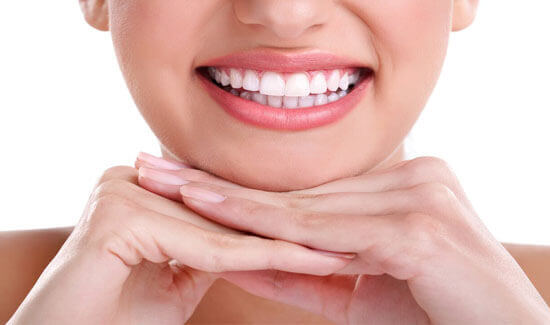 Portrait picture of a smiling woman with perfect white teeth, looking at the camera and showing her happiness with the dental whitening she had at Premier Holistic Dental in beautiful Costa Rica.