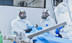 Picture of two dentists performing a Huggins-Grube Protocol dental treatment at Premier Holistic Dental in beautiful Costa Rica.  The dentists are wearing protective equipment and masks.