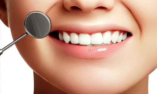 Picture of a smiling woman showing her perfect teeth and happy with the periodontics dental work she had done at Premier Holistic Dental in beautiful Costa Rica.  A dental tool is visible outside of her mouth indicating how periodontics work is done.